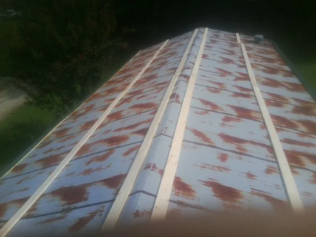 Rusted metal roof panels with new wood purlins before replacement — Storm Damage Roof Repair in Desert Hot Springs by Roofing Brothers